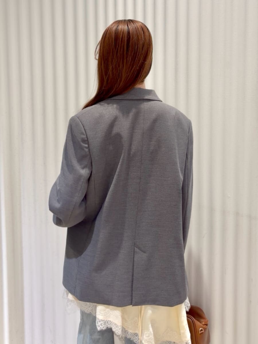 グレー系のテーラードジャケット、ブルー系のデニムパンツ、イエロー系のキャミソールを着用したレディースの春コーディネートの10枚目の写真