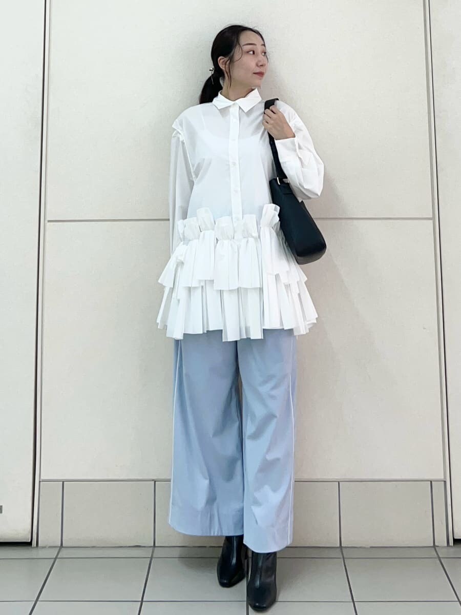 ホワイト系のワンピース、ブルー系のその他パンツ、ブラック系のブーツを着用したレディースの秋コーディネートの2枚目の写真