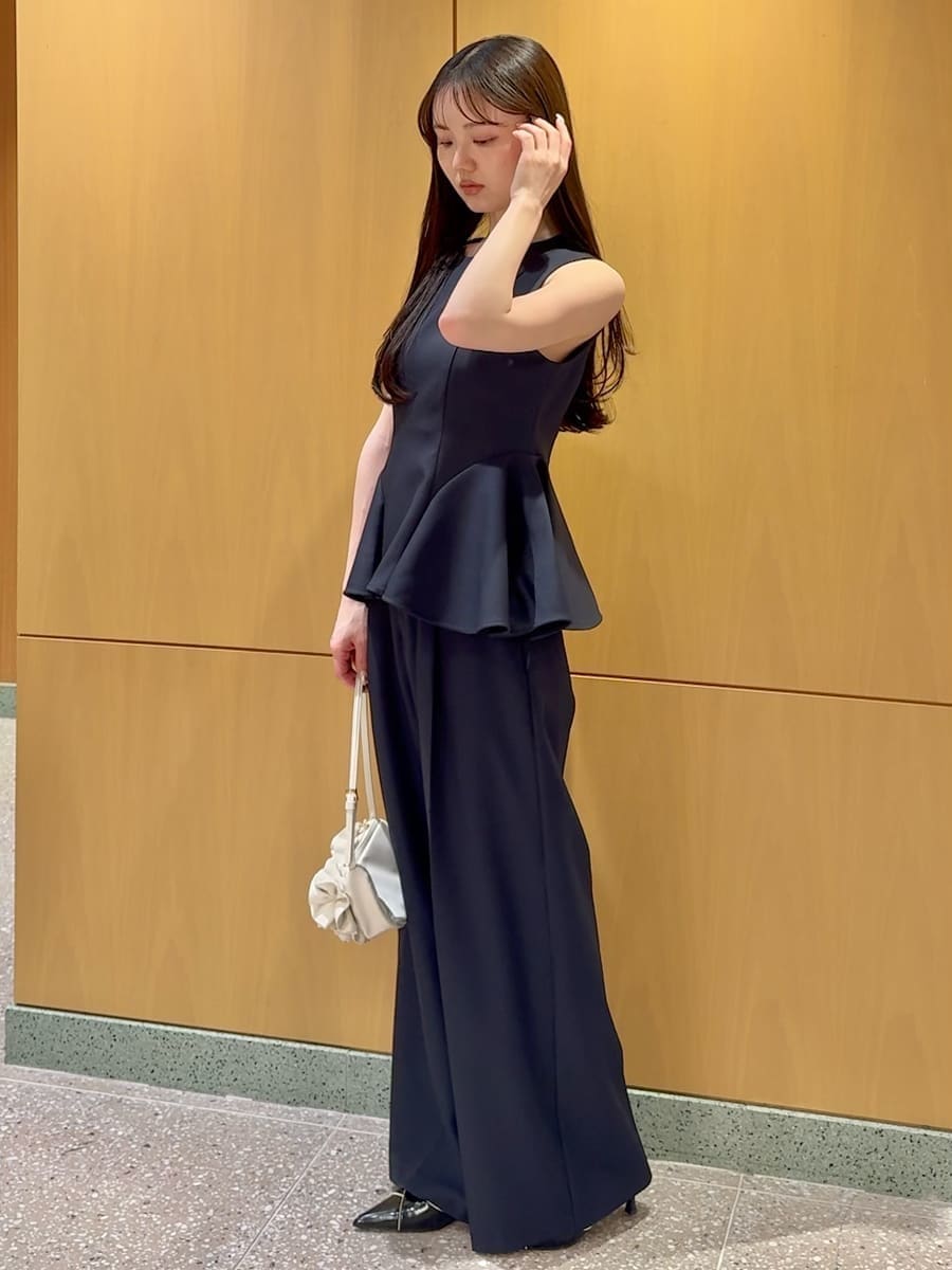 ブルー系のワンピース、ブラック系のパンプス、ホワイト系のハンドバッグを着用したレディースの春コーディネートの2枚目の写真