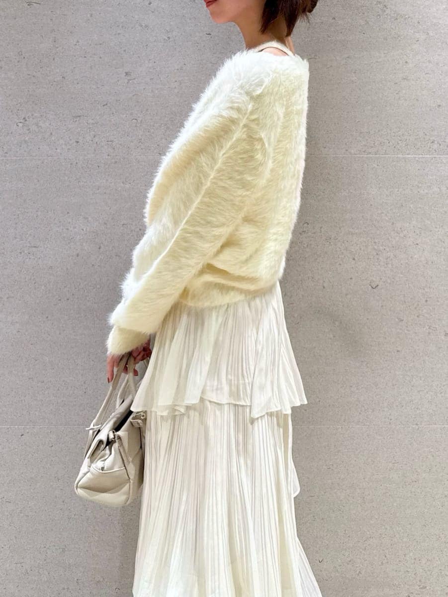 ブラウン系のブーツ、ホワイト系のスカート、イエロー系のニット/セーターを着用したレディースの秋コーディネートの4枚目の写真