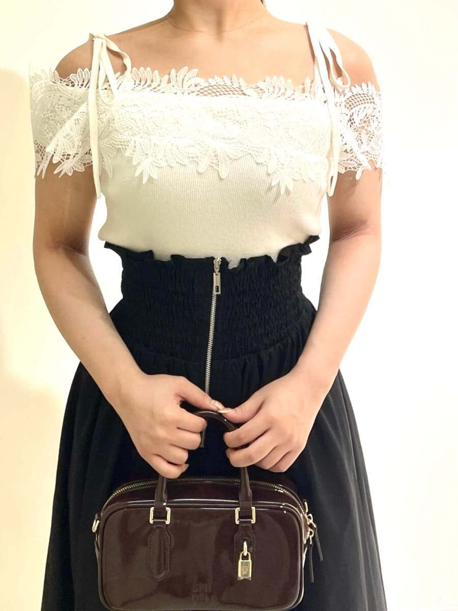 ホワイト系のニット/セーター、ブラック系のスカート、ブラウン系のボストンバッグを着用したレディースの秋コーディネートの5枚目の写真