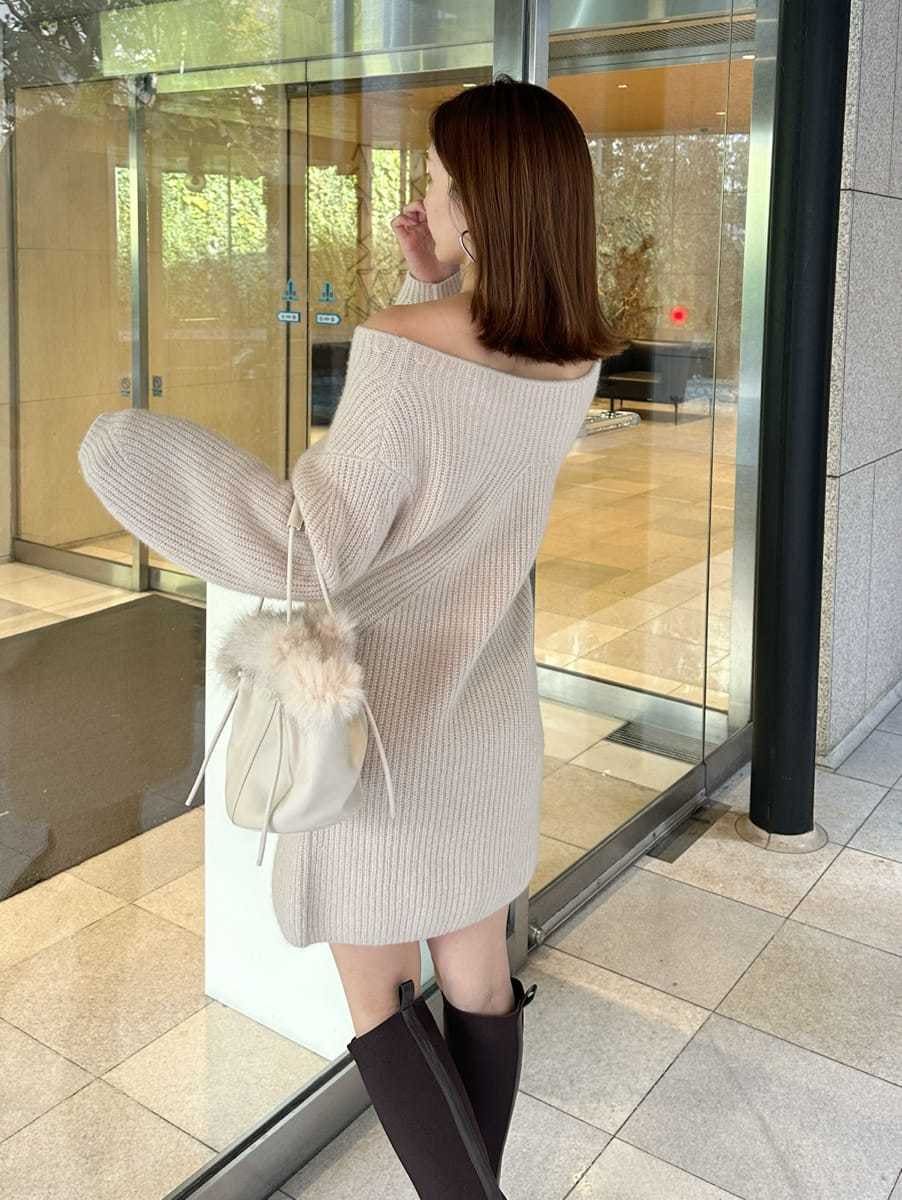 ホワイト系のハンドバッグ、ベージュ系のワンピースを着用したレディースの冬コーディネートの3枚目の写真