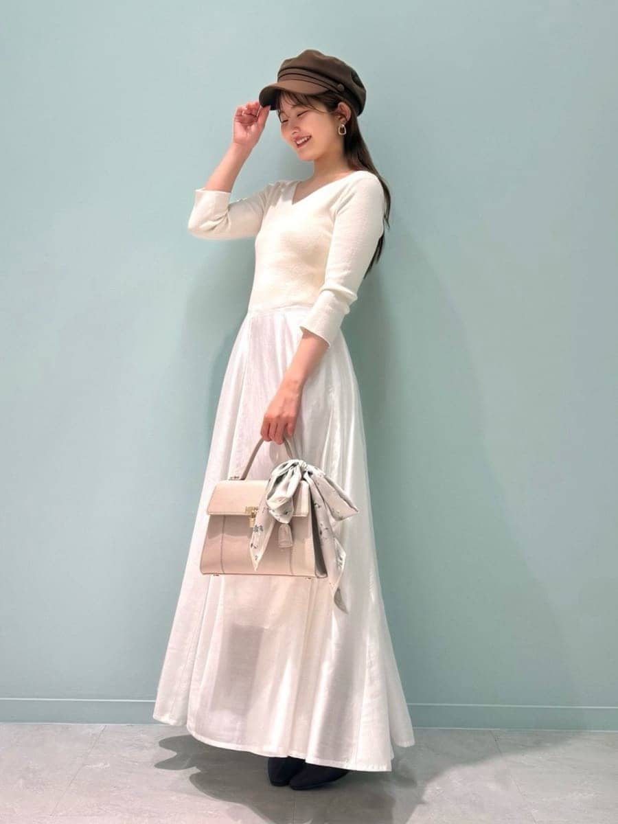 レッド系のブーツ、ベージュ系のトレンチコート、ベージュ系のハンドバッグを着用したレディースの冬コーディネートの5枚目の写真