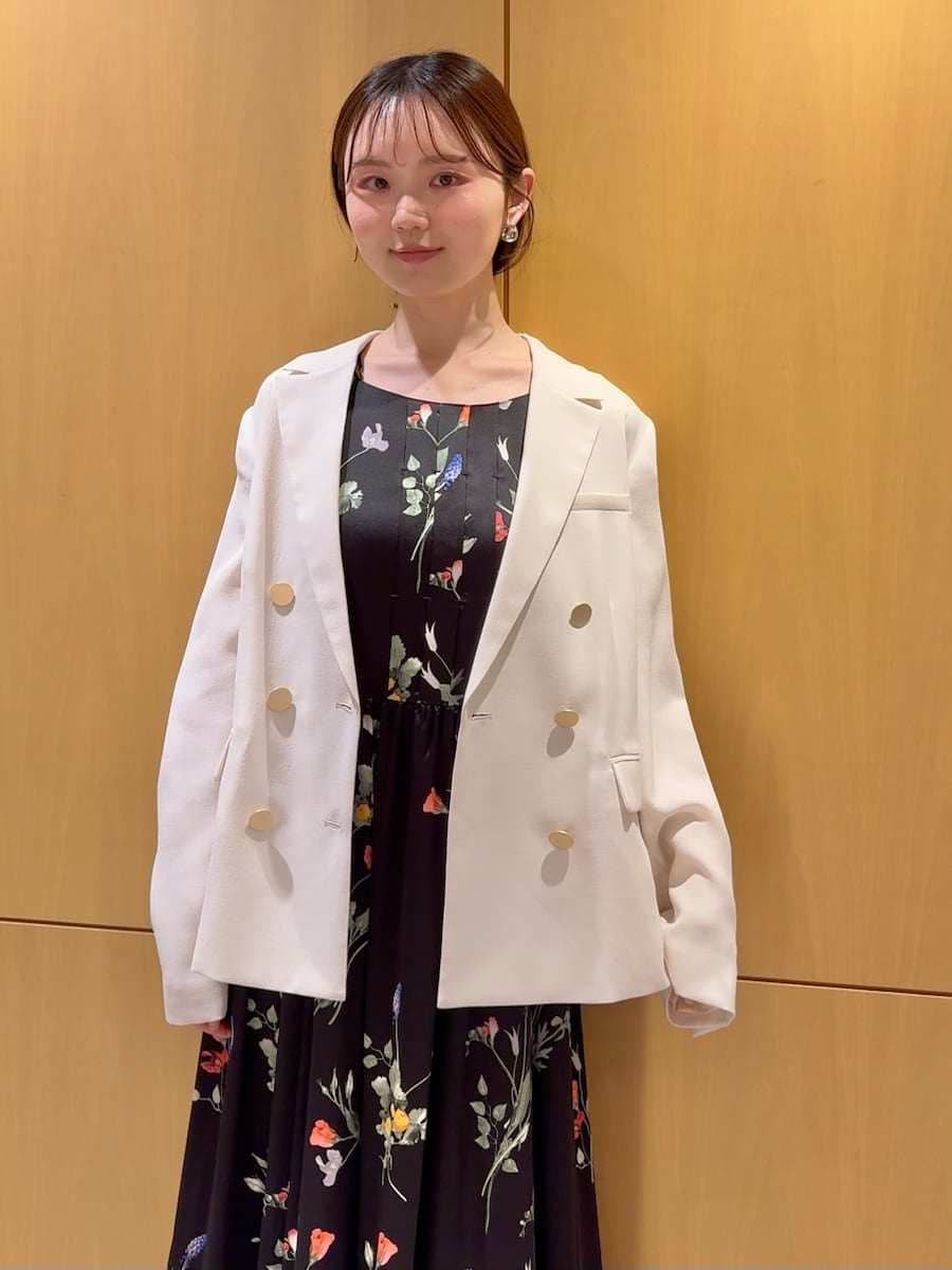 ホワイト系のテーラードジャケット、ブラック系のワンピース、ホワイト系のショルダーバッグを着用したレディースの春コーディネートの6枚目の写真