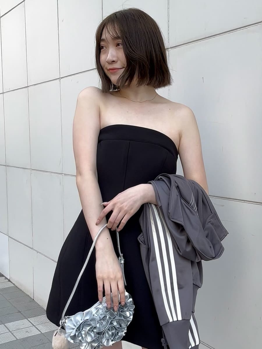 ブラック系のワンピース、シルバー系のハンドバッグ、ブラック系のローファーを着用したレディースの冬コーディネートの6枚目の写真