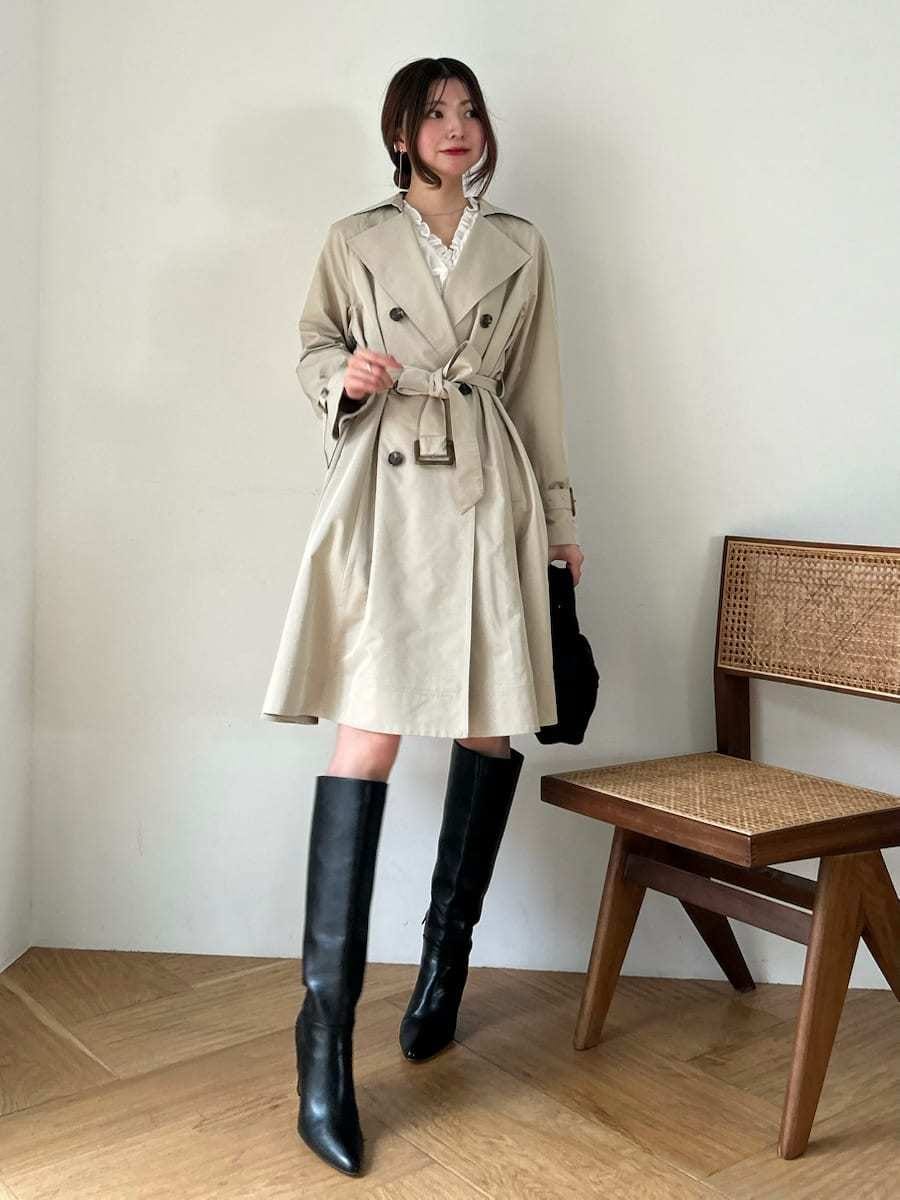 ブラック系のブーツ、ホワイト系のその他トップス、ベージュ系のトレンチコートを着用したレディースの春コーディネートの5枚目の写真