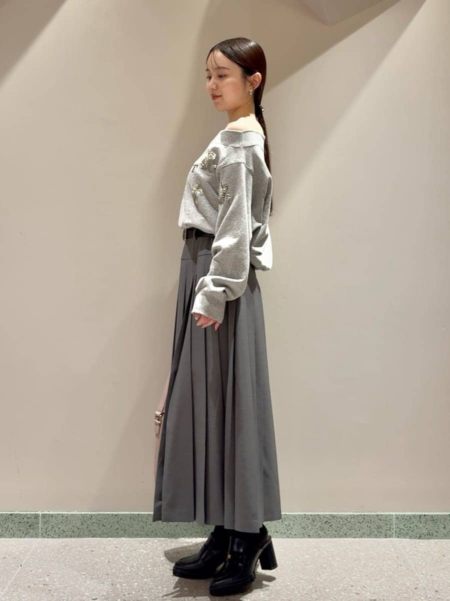 グレー系のスウェット、グレー系のスカート、ブラック系のローファーを着用したレディースの秋コーディネートの2枚目の写真