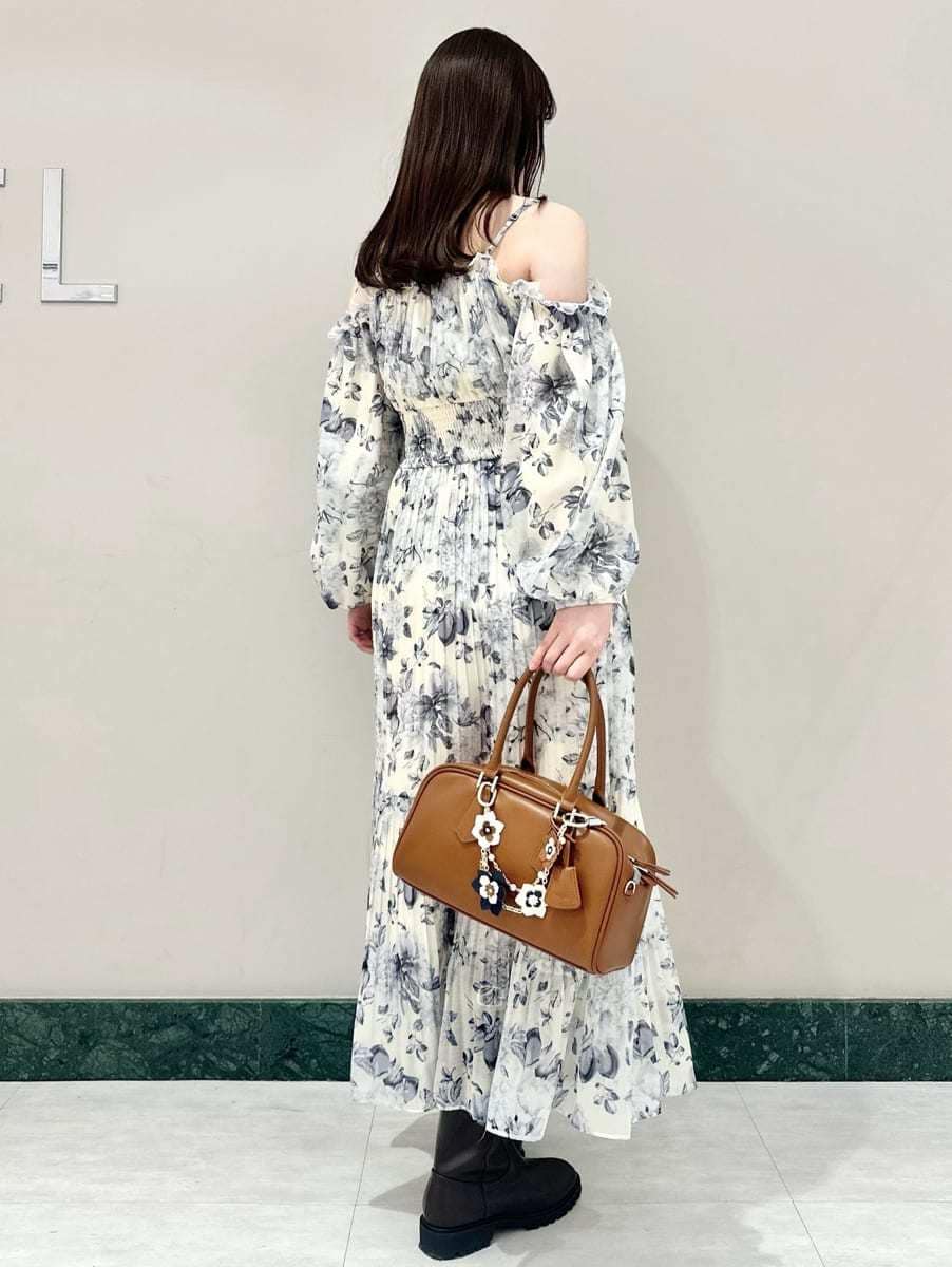 イエロー系のワンピース、イエロー系のボストンバッグ、ブラウン系のキーケース/キーアクセサリーを着用したレディースの冬コーディネートの4枚目の写真