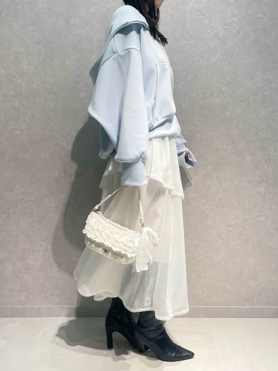 ブラック系のブーツ、ホワイト系のスカート、ブルー系のパーカーを着用したレディースの冬コーディネートの4枚目の写真