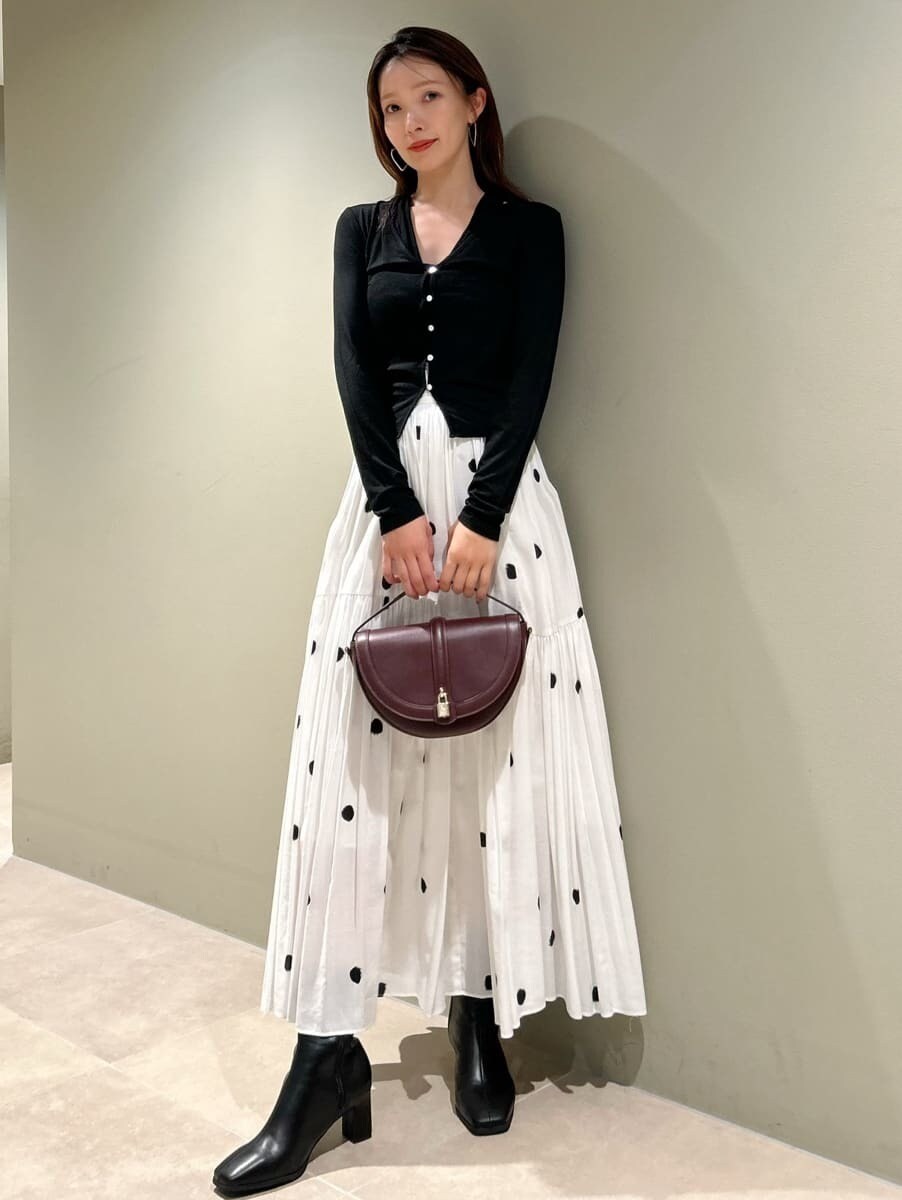 その他のスカート、ブラック系のブーツ、ブラウン系のハンドバッグを着用したレディースの秋コーディネートの4枚目の写真