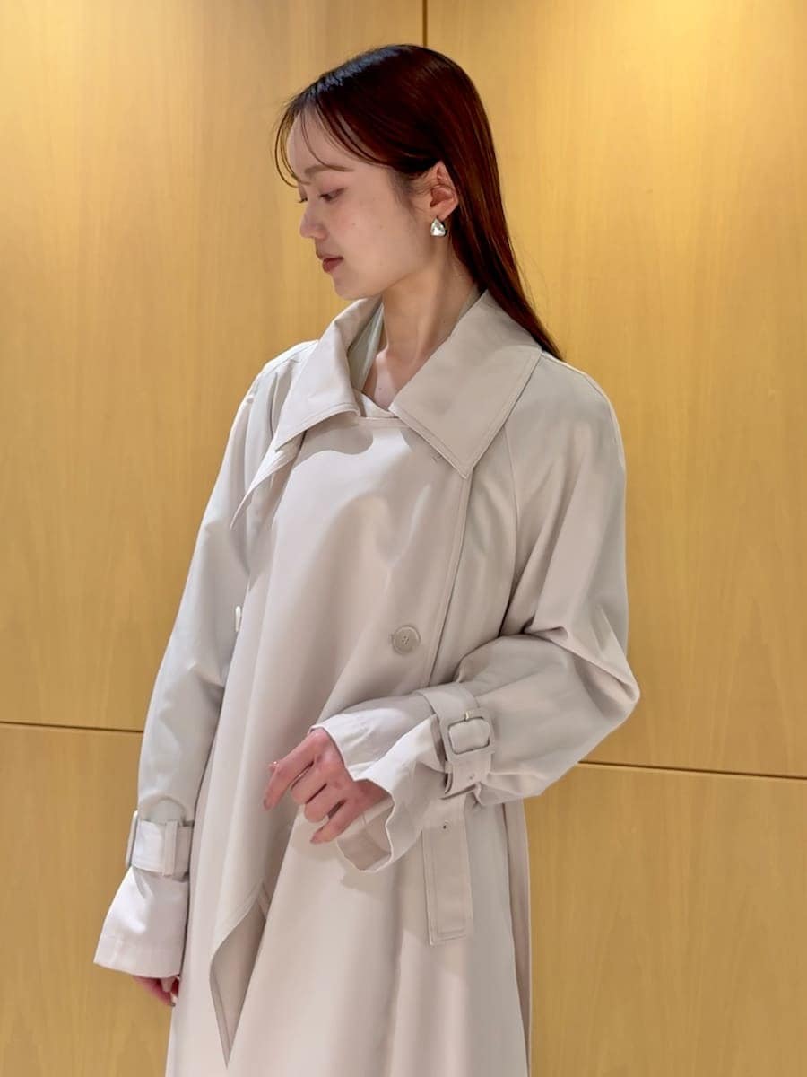 ブラック系のブーツ、ホワイト系のトレンチコート、ホワイト系のスカートを着用したレディースの冬コーディネートの7枚目の写真