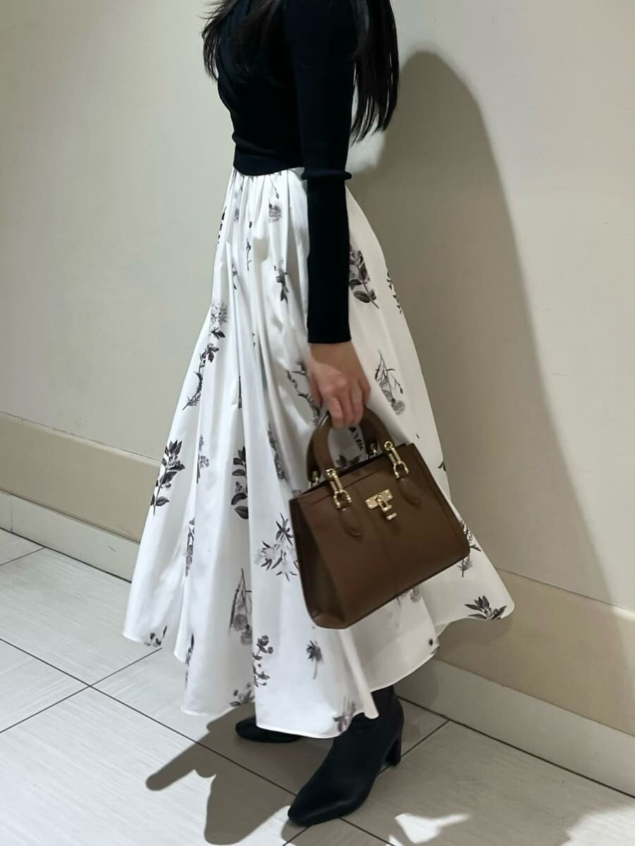 ブラック系のブーツ、ブラウン系のハンドバッグ、ブラウン系のチェスターコートを着用したレディースの冬コーディネートの6枚目の写真