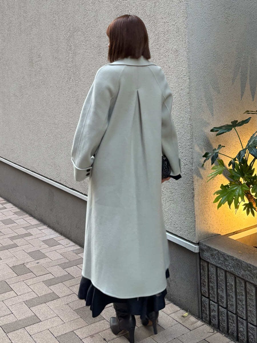 グレー系のブーツ、グリーン系のチェスターコート、ブラック系のワンピースを着用したレディースの秋コーディネートの5枚目の写真