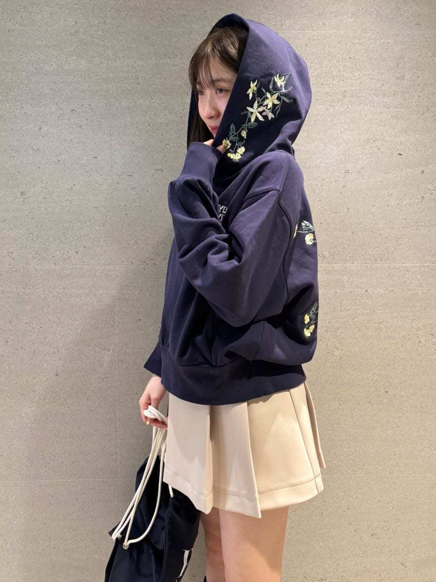 ベージュ系のスカート、ホワイト系のパーカー、ブルー系のバックパック/リュックを着用したレディースの冬コーディネートの6枚目の写真