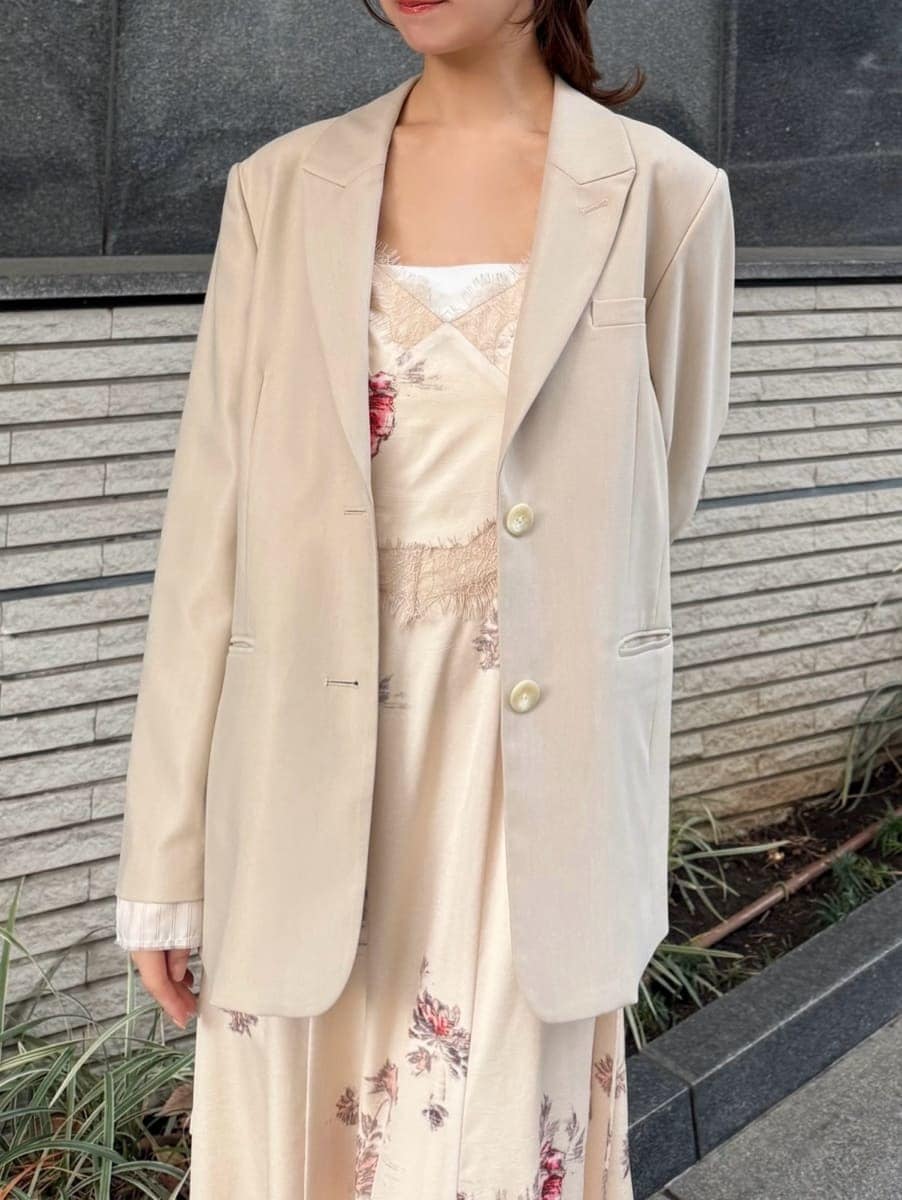 ホワイト系のキャミソール、ベージュ系のテーラードジャケット、ホワイト系のワンピースを着用したレディースの冬コーディネートの3枚目の写真