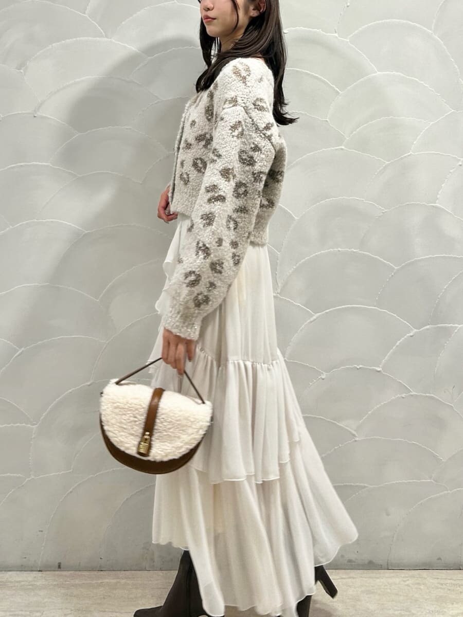 レッド系のブーツ、イエロー系のハンドバッグ、ホワイト系のスカートを着用したレディースの秋コーディネートの3枚目の写真