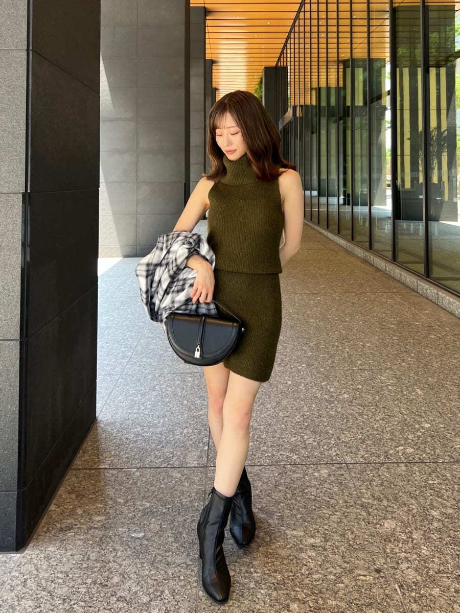 グリーン系のワンピース、ブラック系のシャツ/ブラウス、ブラック系のハンドバッグを着用したレディースの秋コーディネートの6枚目の写真