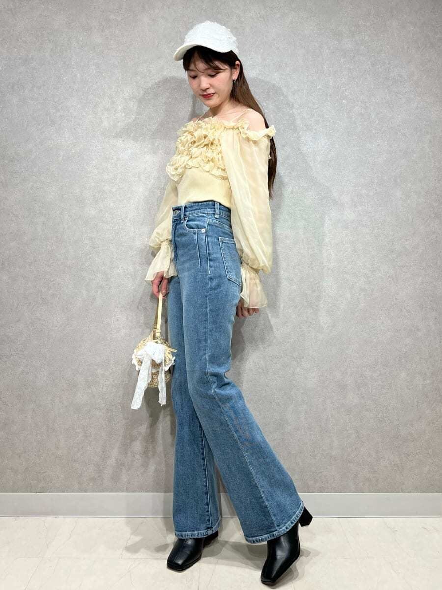 ブルー系のその他パンツ、イエロー系のニット/セーター、ホワイト系のキャップを着用したレディースの冬コーディネートの2枚目の写真