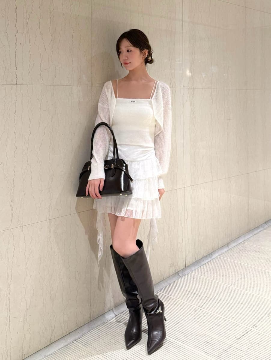 ホワイト系のその他パンツ、ホワイト系のカーディガン/ボレロ、ブラウン系のブーツを着用したレディースの秋コーディネートの4枚目の写真