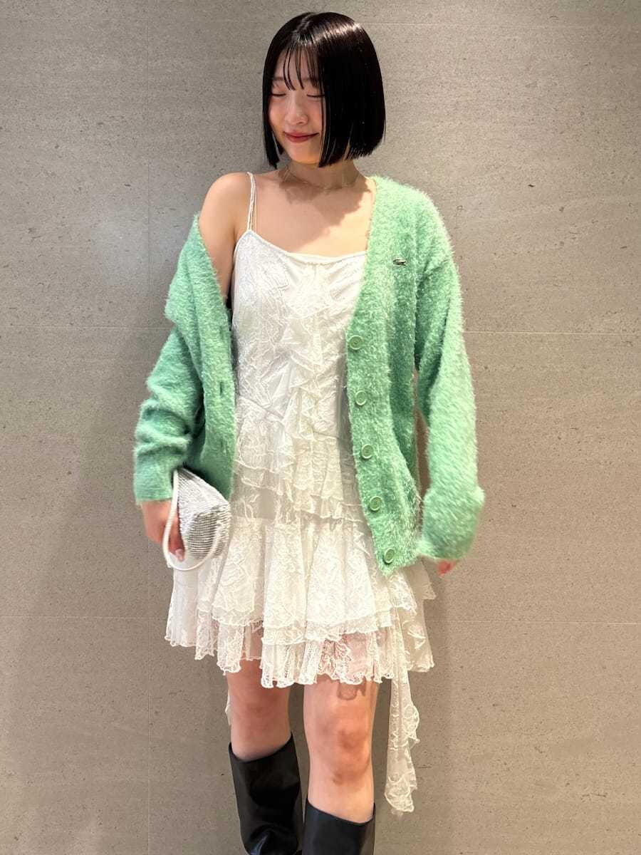 ホワイト系のワンピース、グリーン系のカーディガン/ボレロ、ブラック系のブーツを着用したレディースの冬コーディネートの4枚目の写真