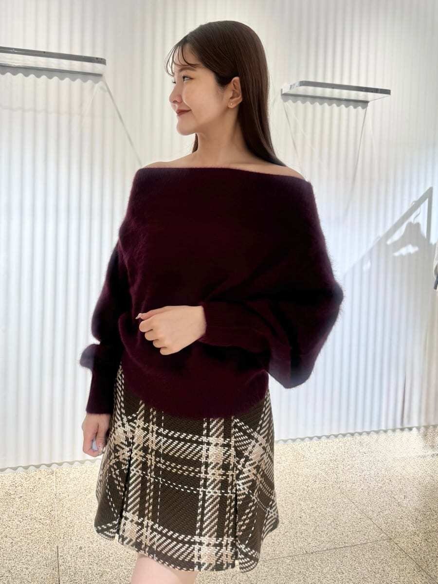 レッド系のニット/セーター、ブラウン系のスカート、レッド系のブーツを着用したレディースの秋コーディネートの4枚目の写真