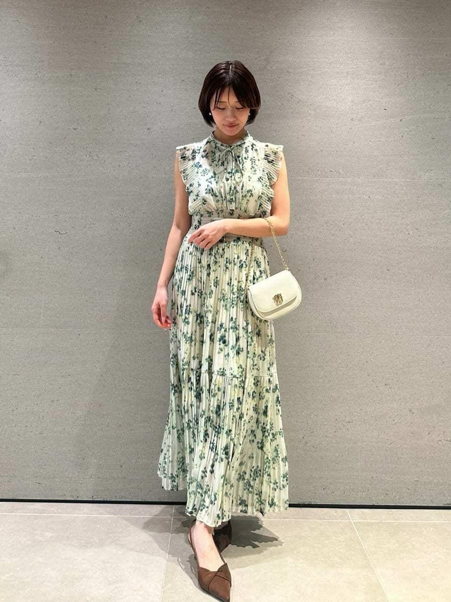 グリーン系のワンピース、ホワイト系のカーディガン/ボレロ、ブラウン系のパンプスを着用したレディースの冬コーディネートの7枚目の写真