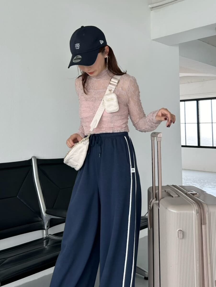 ブルー系のスウェットパンツ、ホワイト系のショルダーバッグ、ブルー系のキャップを着用したレディースの夏コーディネートの2枚目の写真