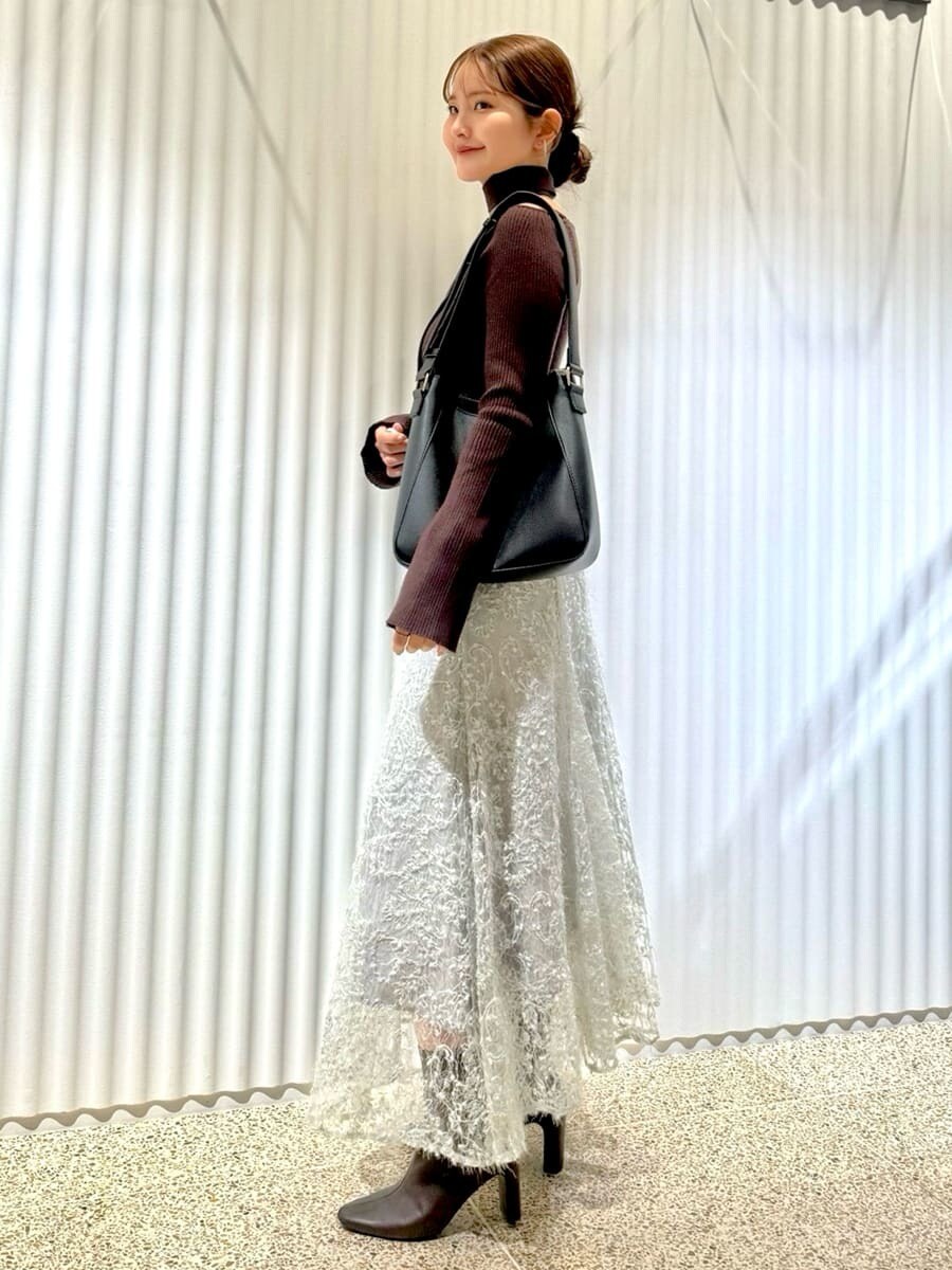 ブラウン系のニット/セーター、グリーン系のスカート、レッド系のブーツを着用したレディースの秋コーディネートの4枚目の写真