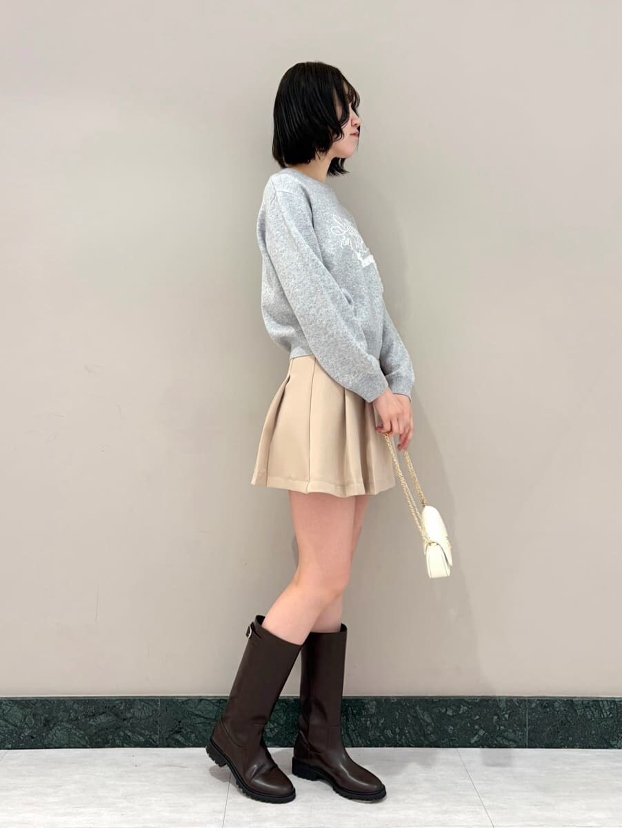 ベージュ系のスカート、グレー系のニット/セーター、ホワイト系のショルダーバッグを着用したレディースの冬コーディネートの3枚目の写真