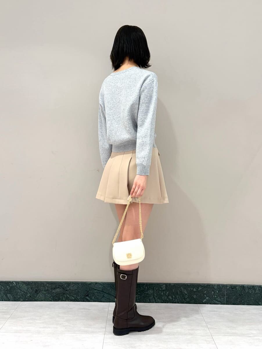 ベージュ系のスカート、グレー系のニット/セーター、ホワイト系のショルダーバッグを着用したレディースの冬コーディネートの2枚目の写真