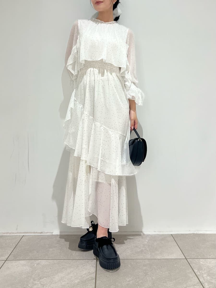 ブラック系のハンドバッグ、ブラック系のその他シューズ、その他のワンピースを着用したレディースの冬コーディネートの6枚目の写真