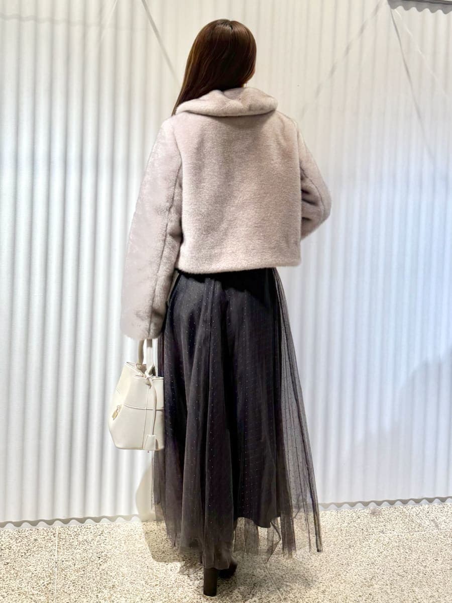 レッド系のブーツ、グレー系のワンピース、ピンク系のステンカラーコートを着用したレディースの秋コーディネートの2枚目の写真