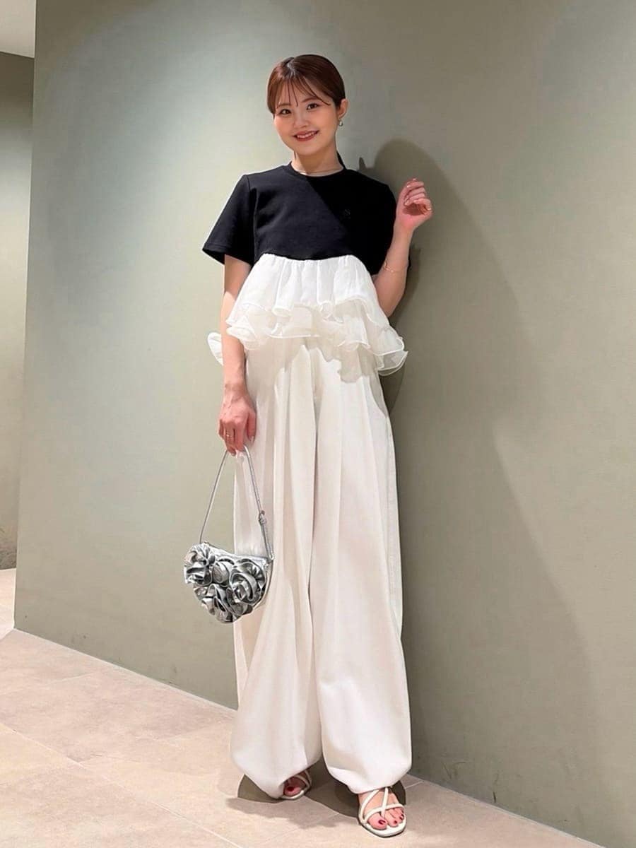 ホワイト系のデニムパンツ、ブラック系のTシャツ/カットソー、シルバー系のハンドバッグを着用したレディースの春コーディネートの3枚目の写真