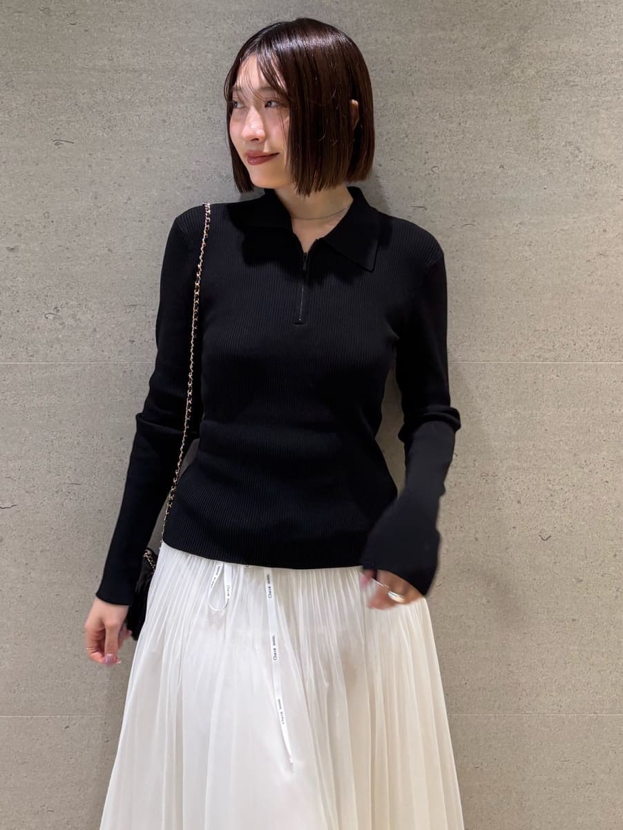 ブラック系のニット/セーター、ホワイト系のスカートを着用したレディースの秋コーディネートの4枚目の写真