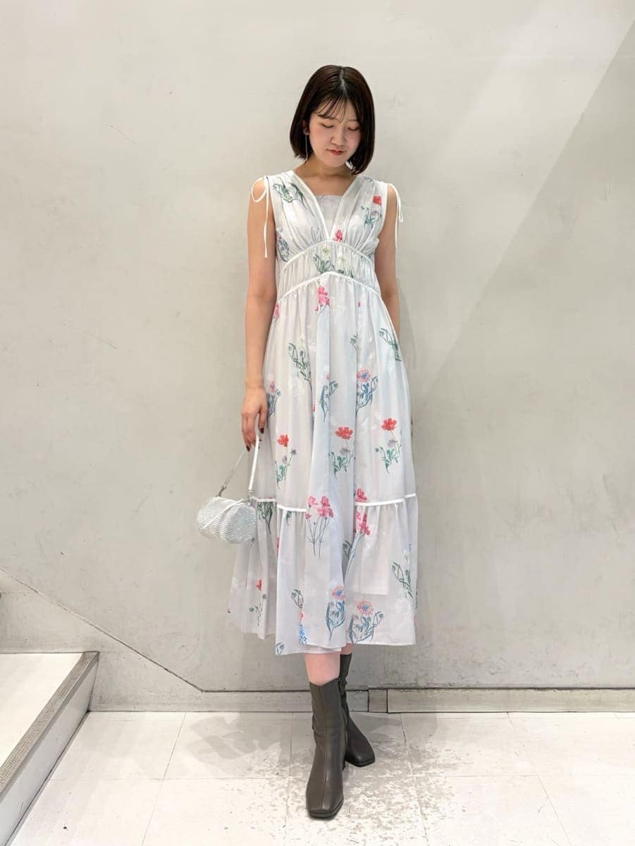 グレー系のワンピース、グレー系のチェスターコート、ゴールド系のイヤリングを着用したレディースの冬コーディネートの3枚目の写真