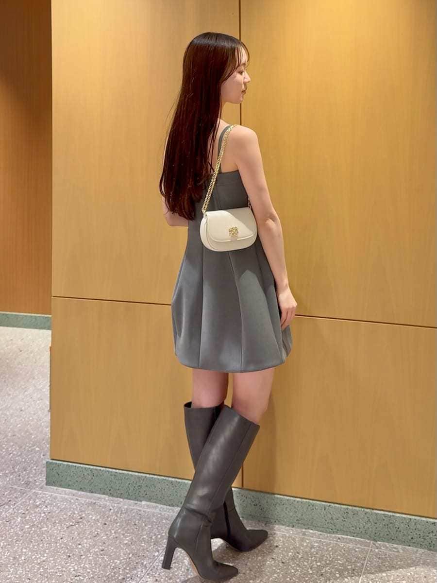 グレー系のブーツ、ホワイト系のトレンチコート、グレー系のワンピースを着用したレディースの冬コーディネートの6枚目の写真