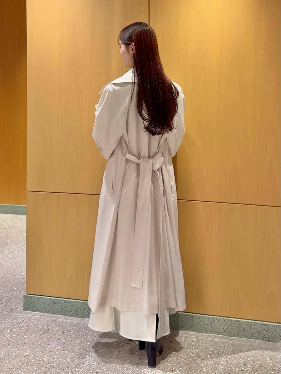 ブラック系のブーツ、ホワイト系のトレンチコート、ホワイト系のスカートを着用したレディースの冬コーディネートの3枚目の写真