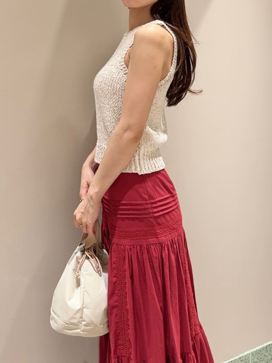 ホワイト系のニット/セーター、レッド系のスカート、ベージュ系のハンドバッグを着用したレディースの夏コーディネートの5枚目の写真