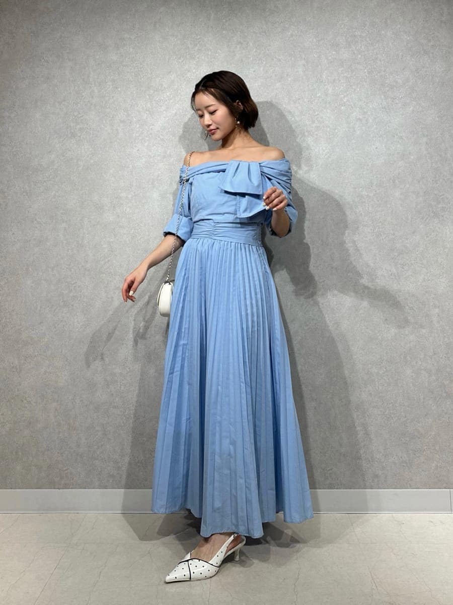 ブルー系のワンピース、その他のパンプス、ホワイト系のショルダーバッグを着用したレディースの冬コーディネートの4枚目の写真