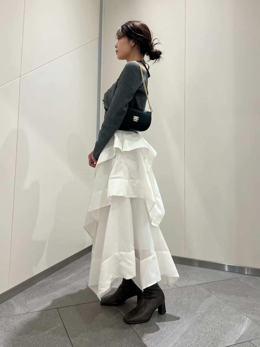 ホワイト系のスカート、グレー系のカーディガン/ボレロ、ブラック系のショルダーバッグを着用したレディースの春コーディネートの2枚目の写真