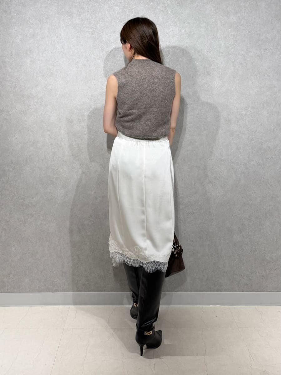 ベージュ系のトレンチコート、ホワイト系のスカート、ブラウン系のTシャツ/カットソーを着用したレディースの秋コーディネートの7枚目の写真