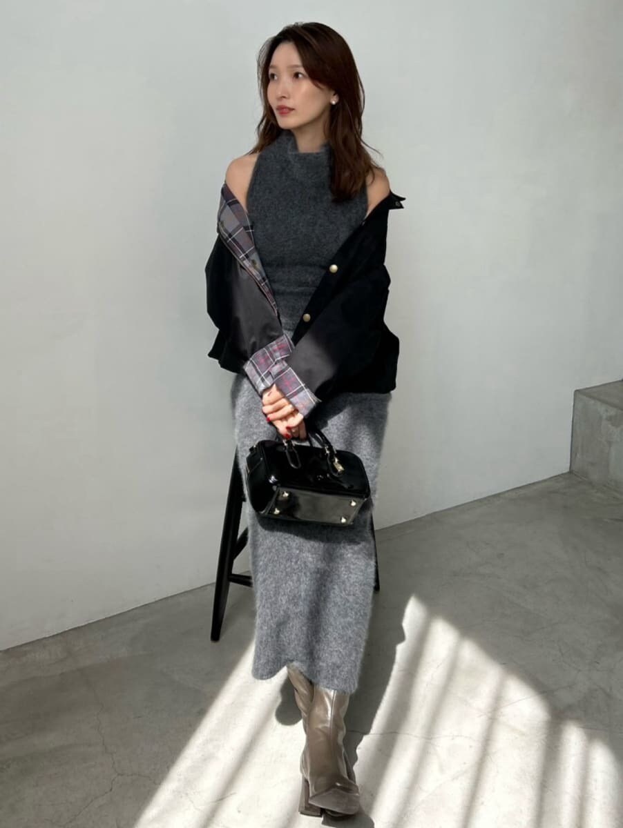 ブラック系のブルゾン、ブラック系のボストンバッグ、グレー系のワンピースを着用したレディースの秋コーディネートの5枚目の写真
