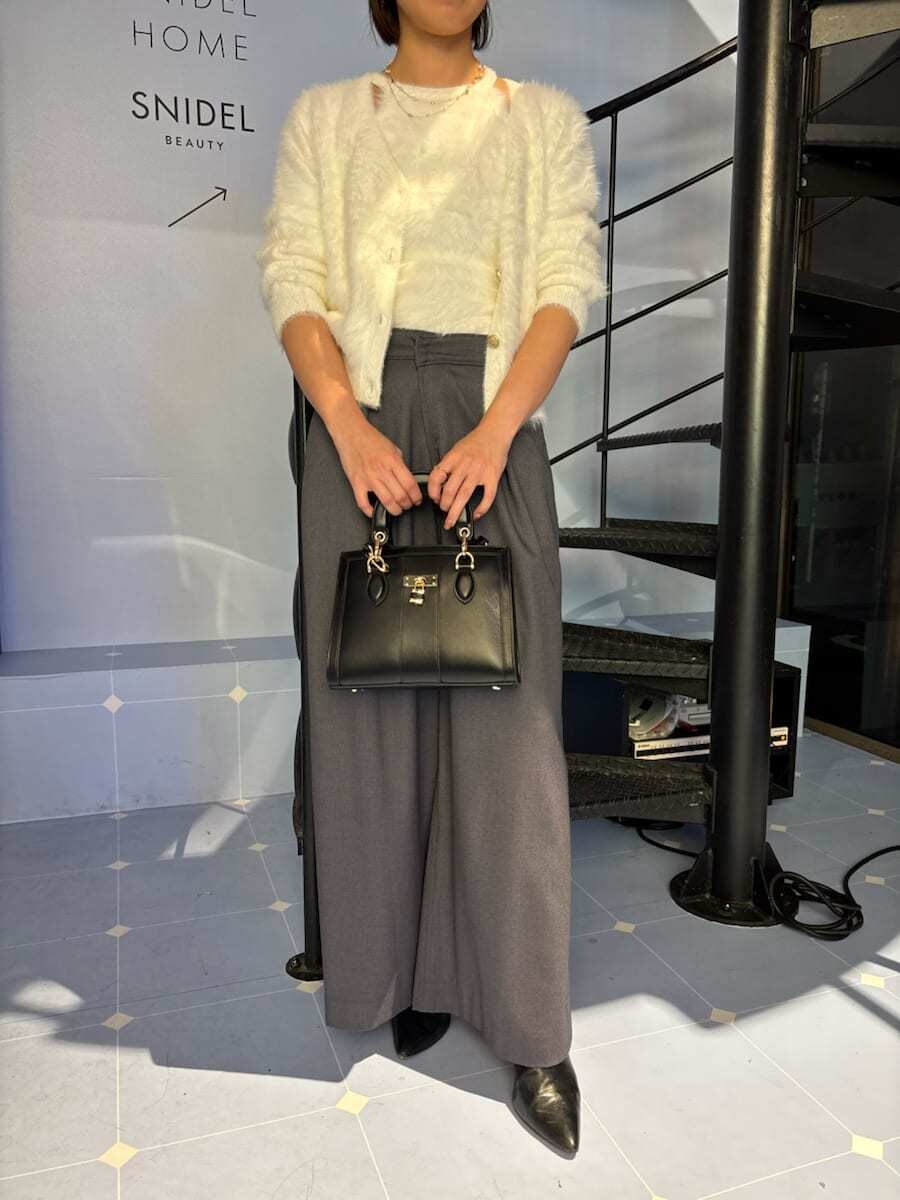 ブラック系のブーツ、ホワイト系のニット/セーター、ブラック系のハンドバッグを着用したレディースの秋コーディネートの8枚目の写真