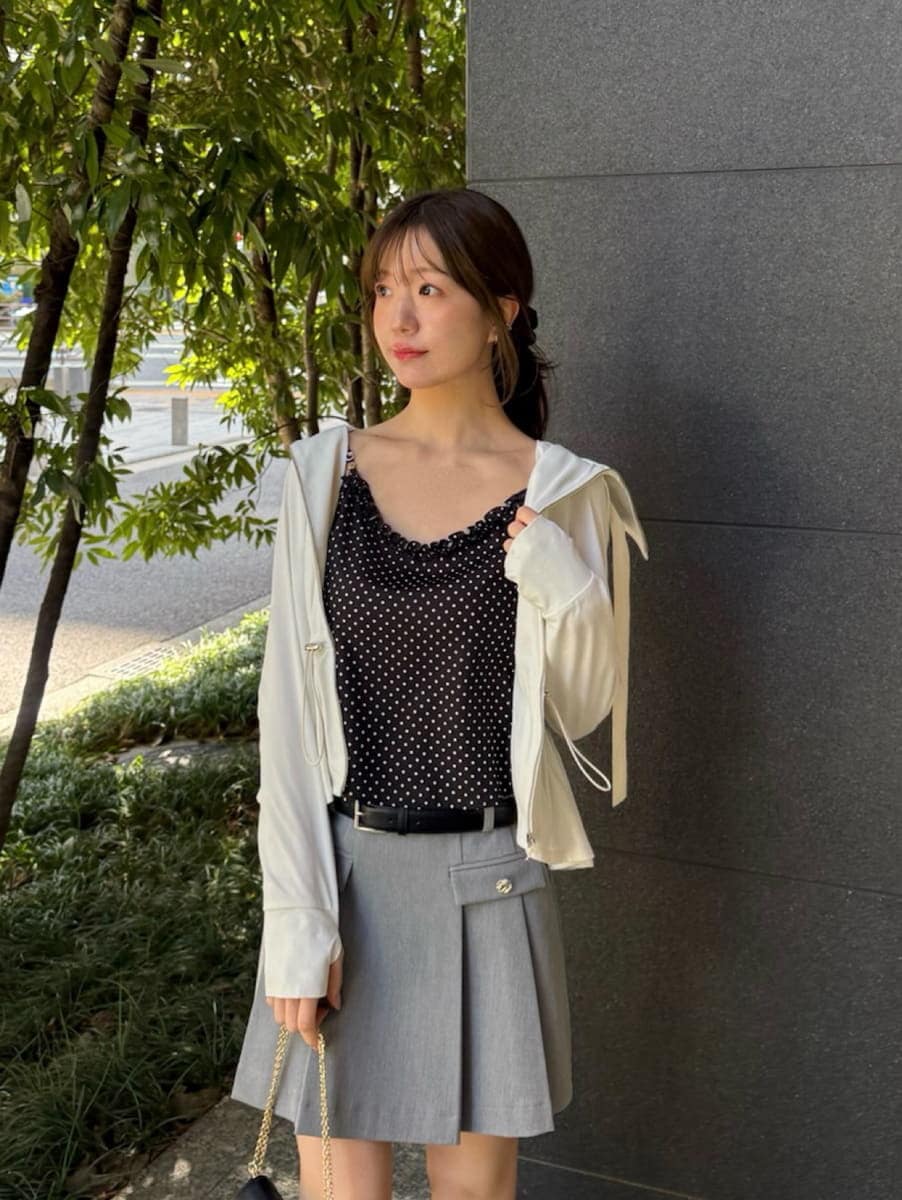 グレー系のスカート、ブラック系のキャミソール、ブラック系のショルダーバッグを着用したレディースの春コーディネートの3枚目の写真