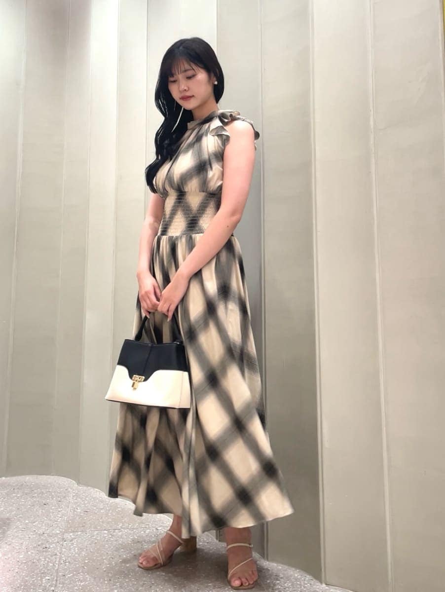 その他のハンドバッグ、ベージュ系のワンピース、その他のサンダルを着用したレディースの夏コーディネートの3枚目の写真