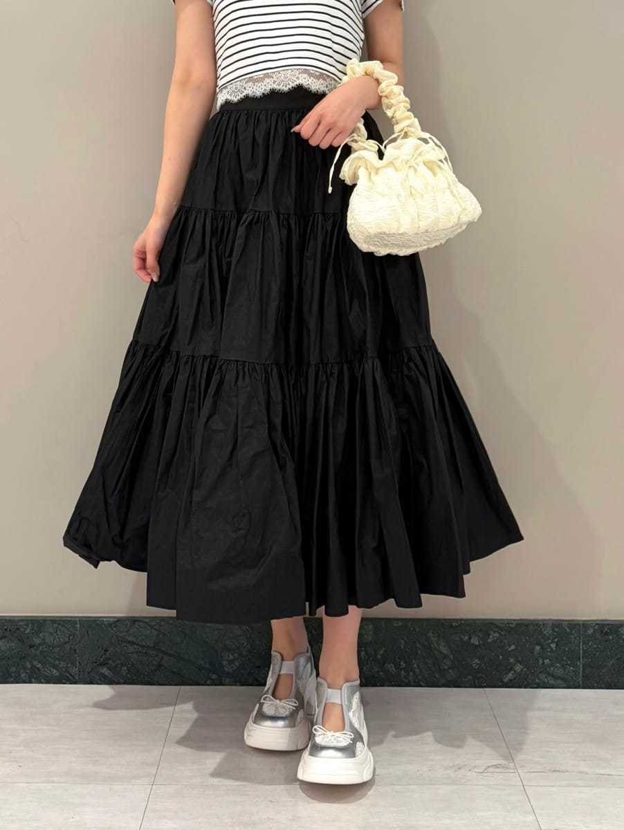 ブラック系のスカート、その他のTシャツ/カットソー、シルバー系のスニーカーを着用したレディースの春コーディネートの4枚目の写真