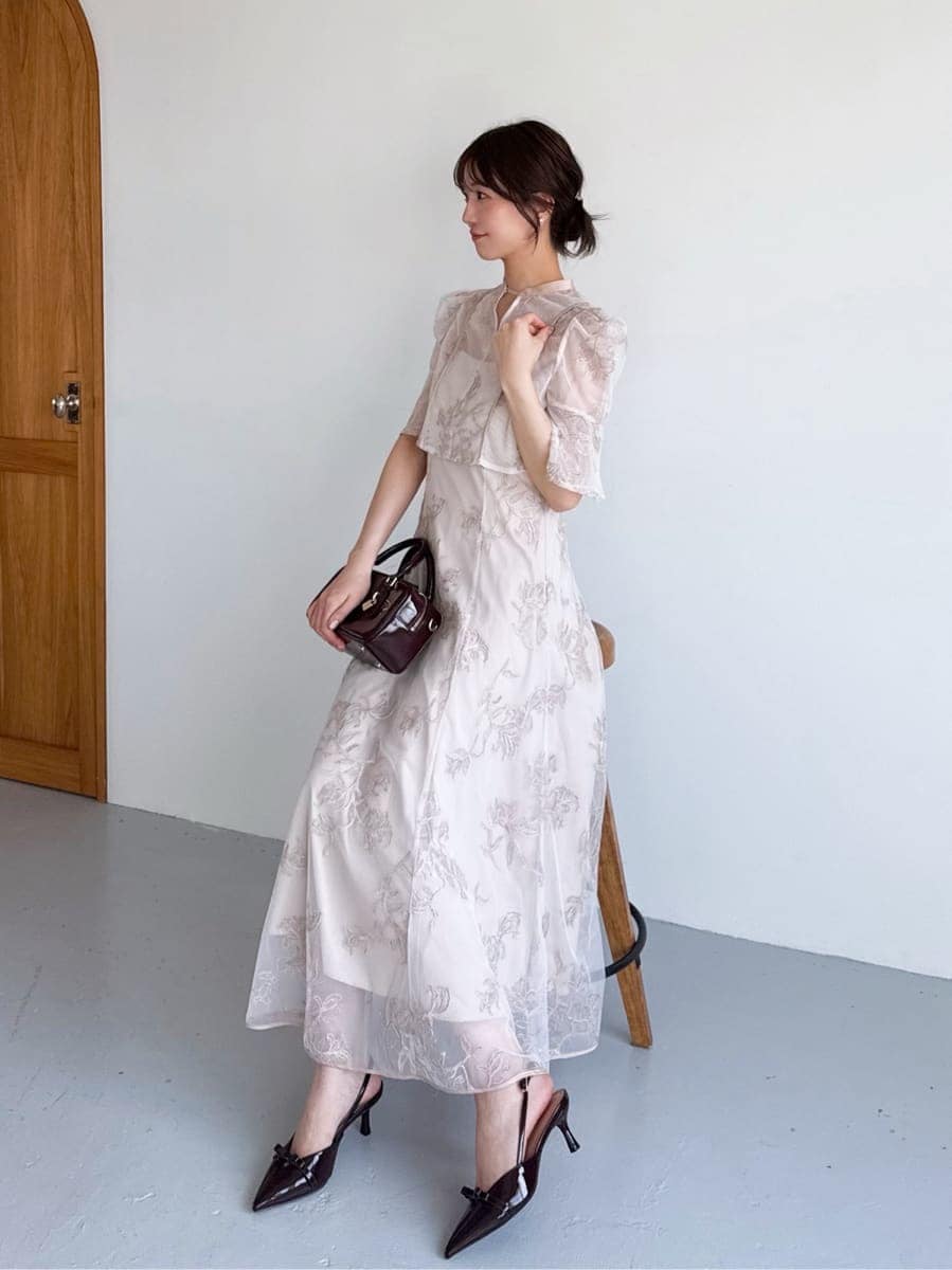 ピンク系のワンピース、ブラウン系のボストンバッグ、シルバー系のイヤリングを着用したレディースの夏コーディネートの5枚目の写真