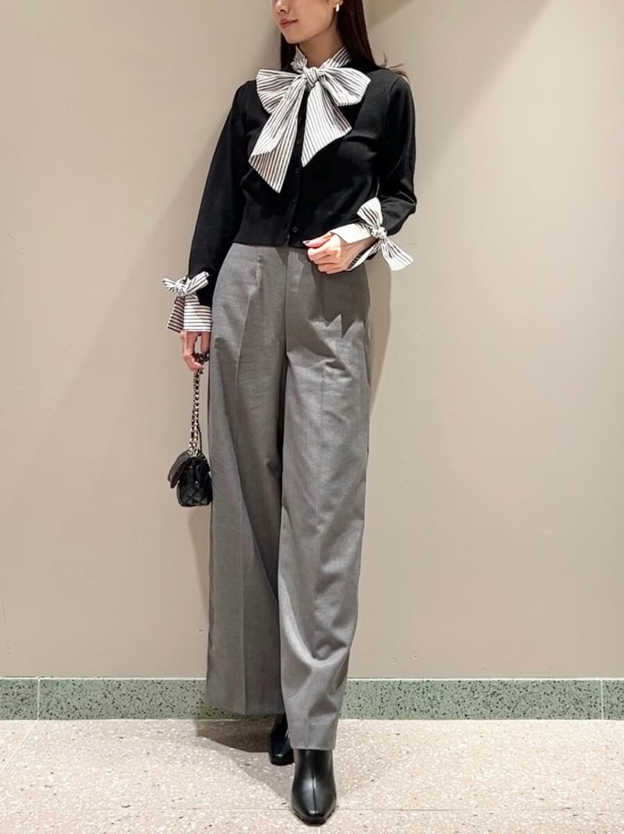 ブラック系のニット/セーター、グレー系のスラックス、ブラック系のショルダーバッグを着用したレディースの秋コーディネートの2枚目の写真