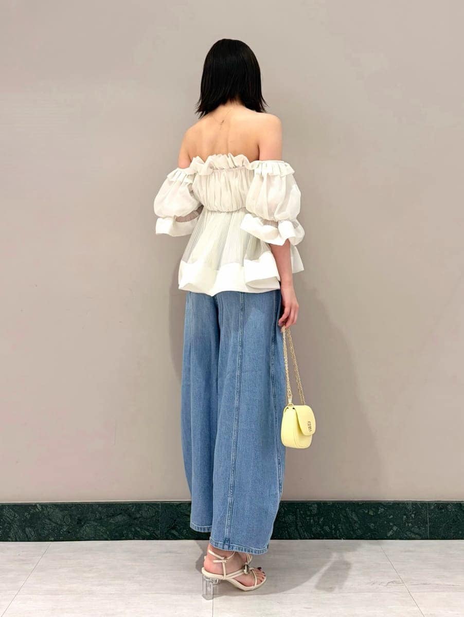 ブルー系のデニムパンツ、ホワイト系のその他トップス、イエロー系のショルダーバッグを着用したレディースの春コーディネートの3枚目の写真