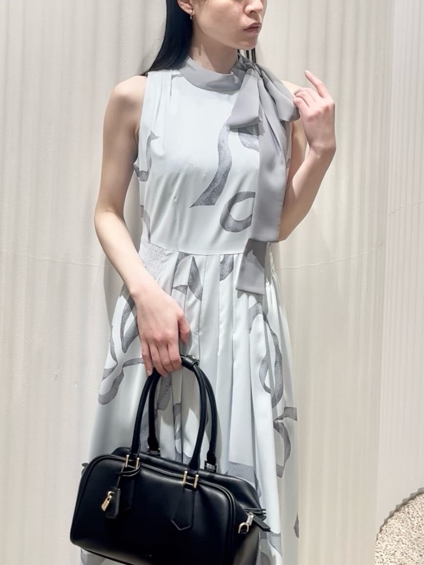 ブルー系のワンピース、ブラック系のパンプス、ブラック系のボストンバッグを着用したレディースの冬コーディネートの5枚目の写真